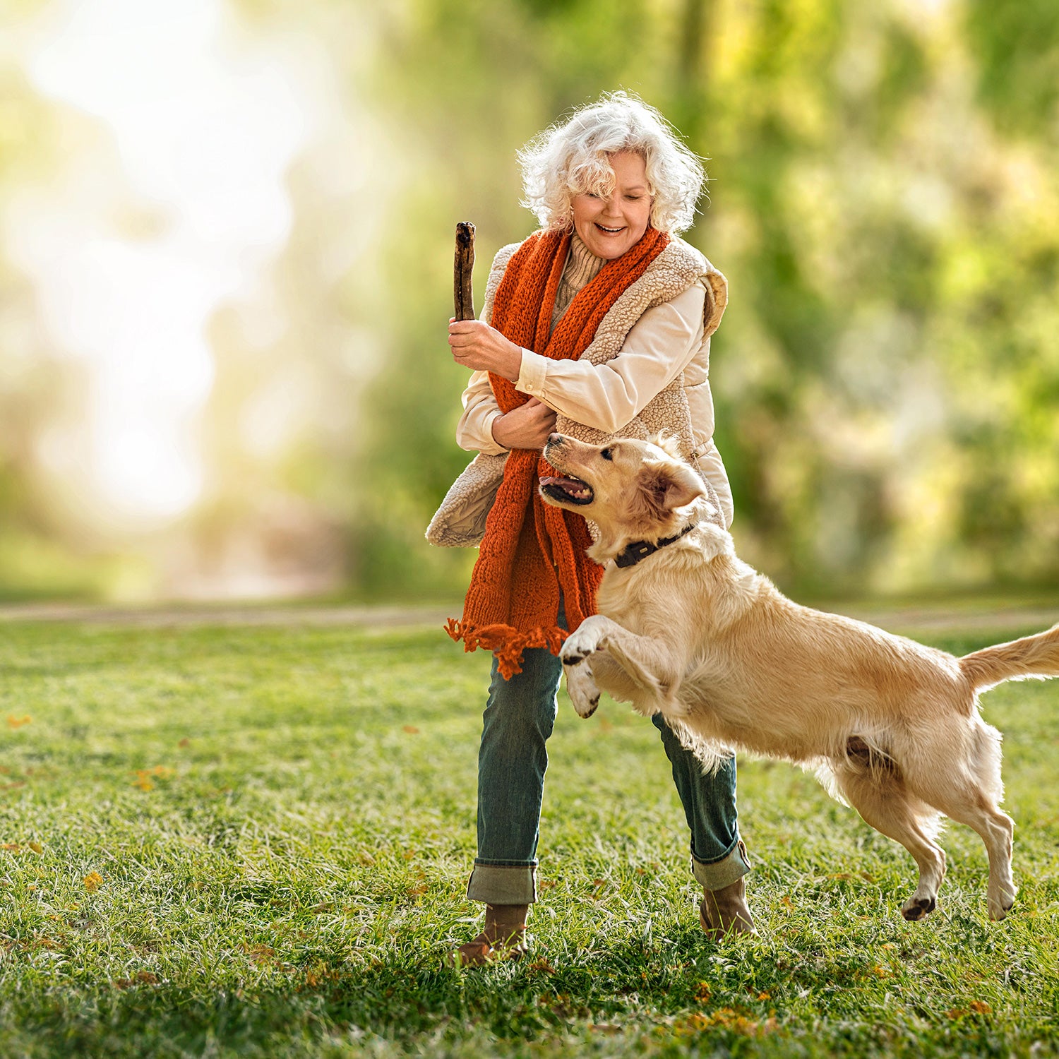 Frau spielt draußen mit ihrem Hund