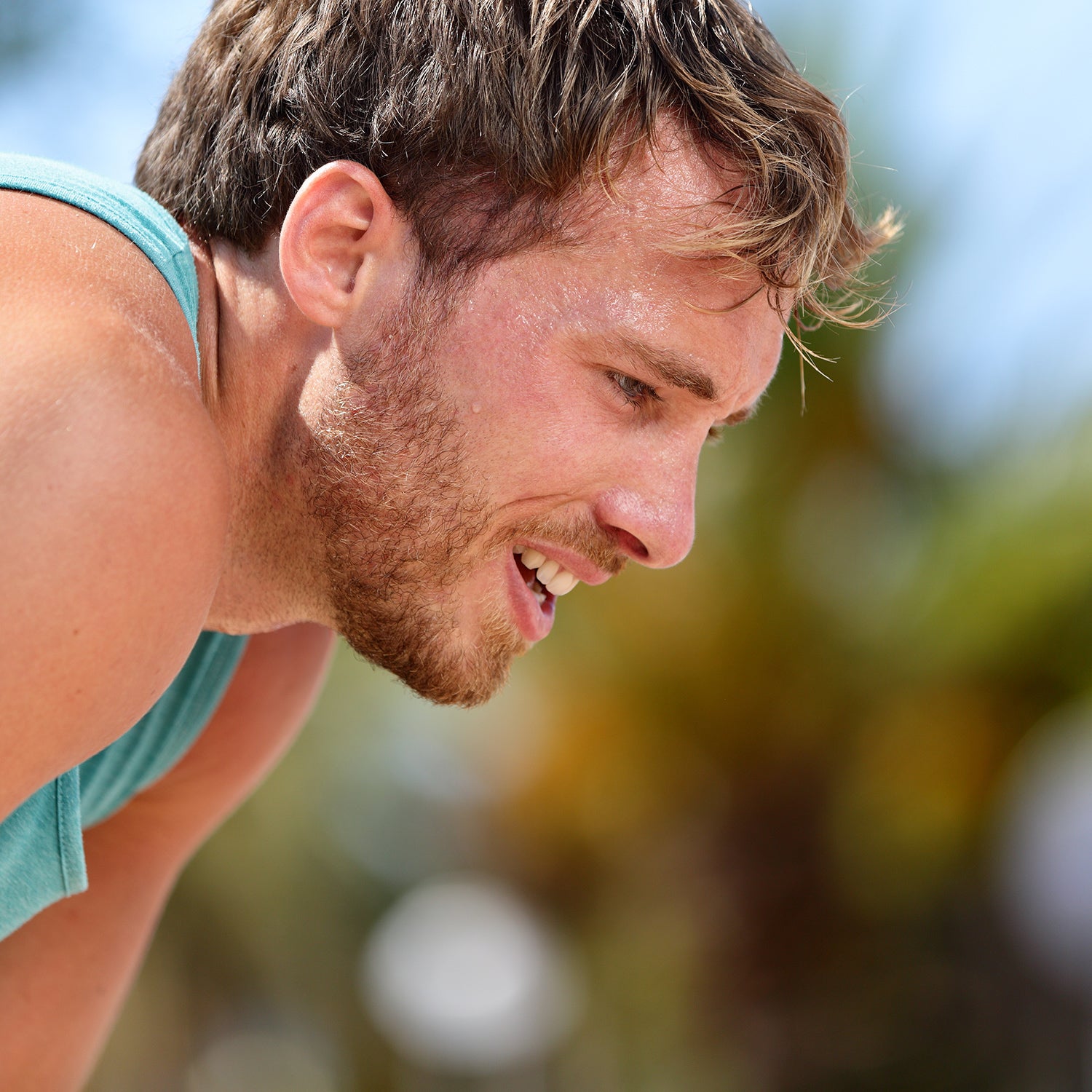 Mann im Sportshirt verschnauft nach Sport