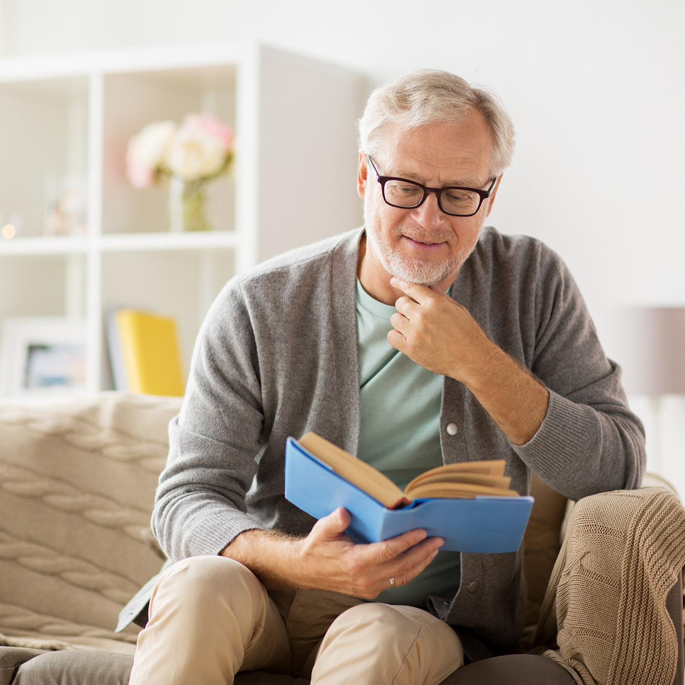Mann liest ein Buch auf dem Sofa
