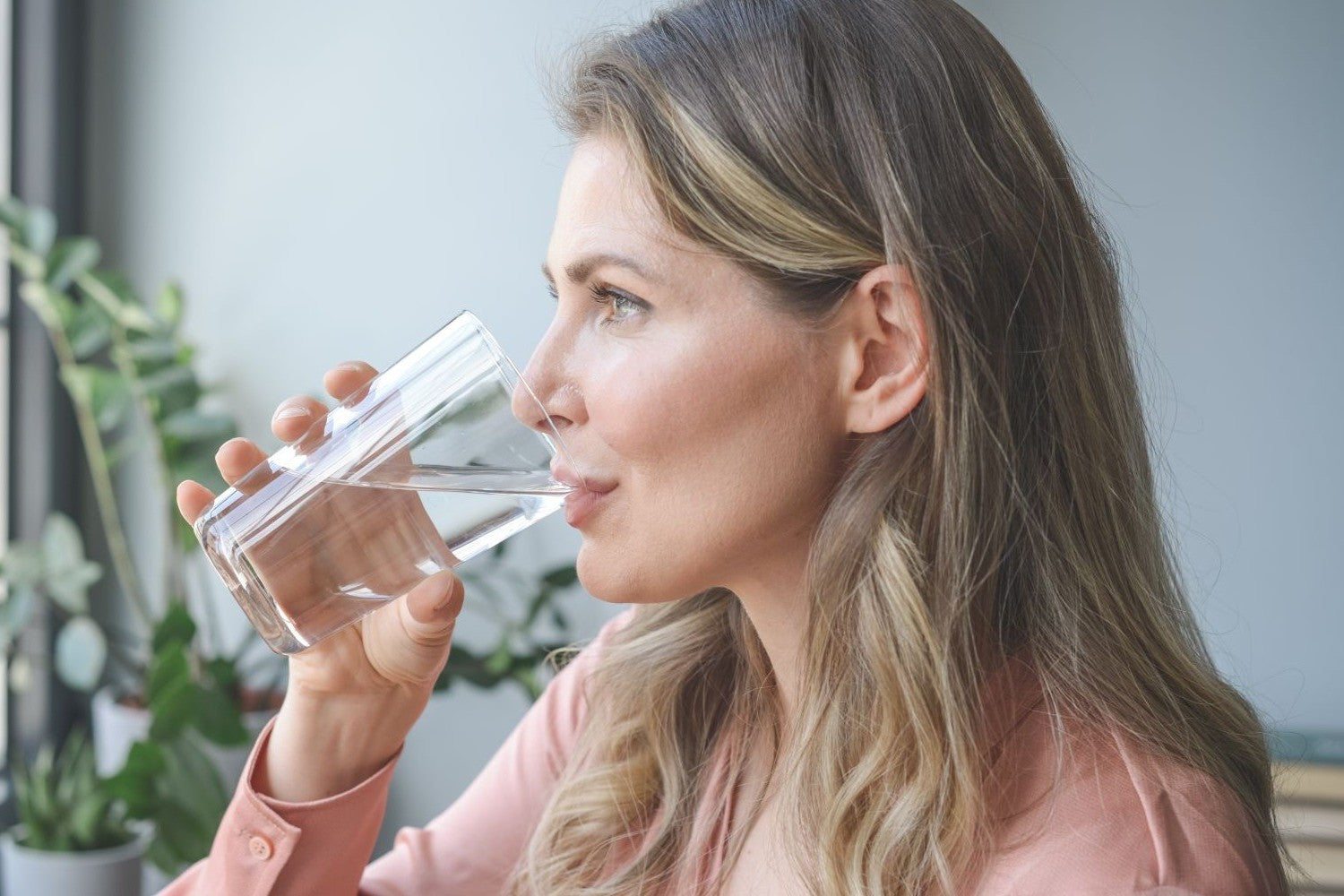 Frau trinkt aus einem Glas Wasser