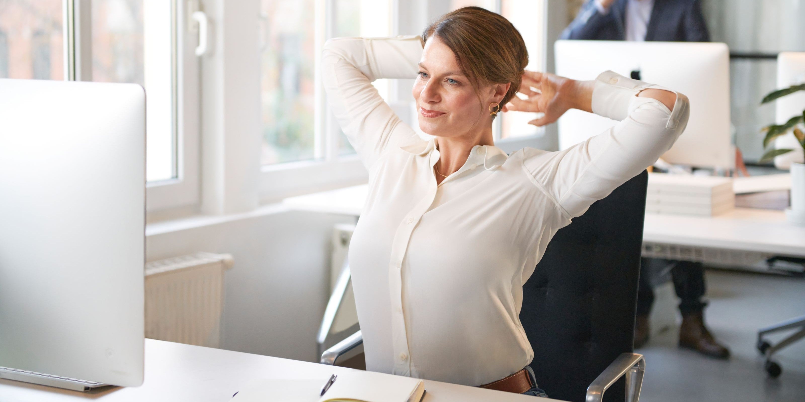 Frau streckt sich im Büro zur Entspannung