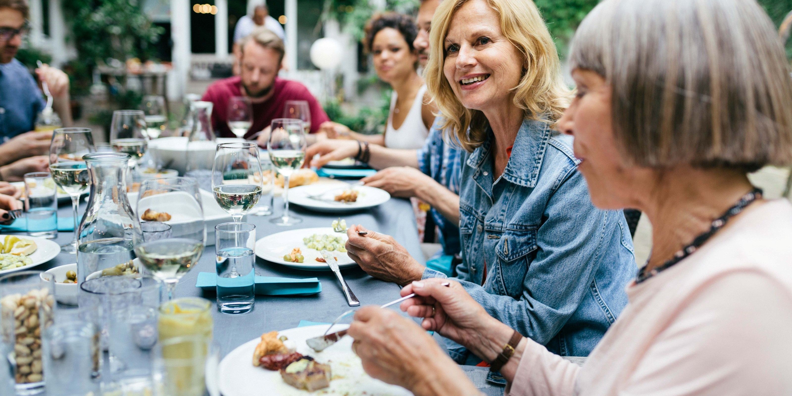 Freunde sitzen draußen zusammen beim Essen