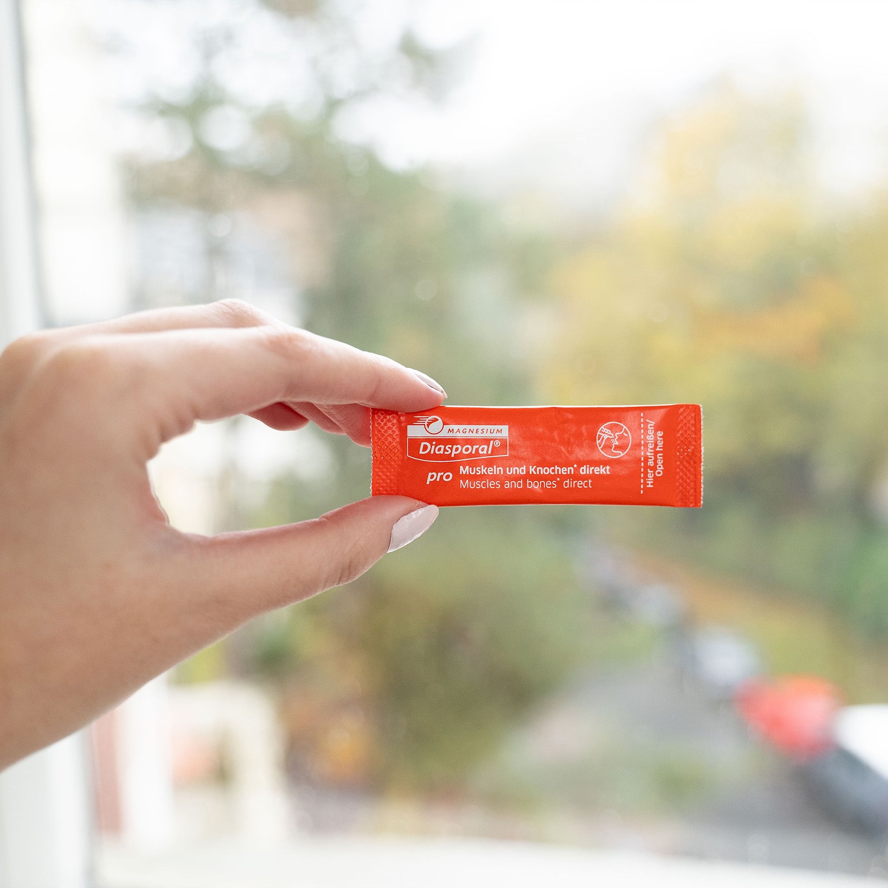 Frau hält einen Stick Magnesium-Diasporal Pro Muskeln und Knochen direkt in der Hand