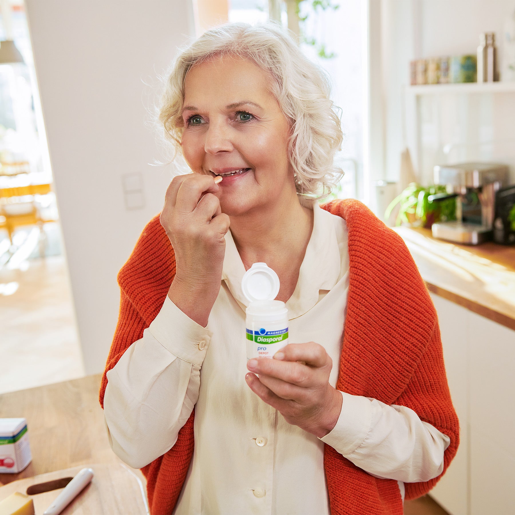Ältere Frau nimmt Magnesium-Diasporal Pro Depot Muskeln und Knochen Tabletten ein