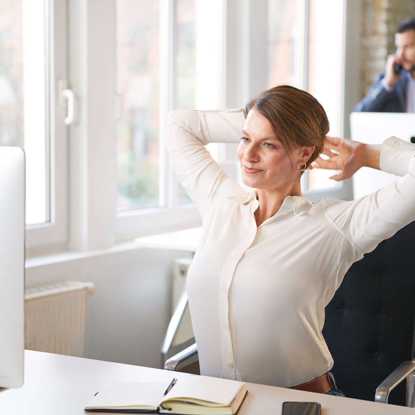 Frau streckt sich im Büro zur Entspannung