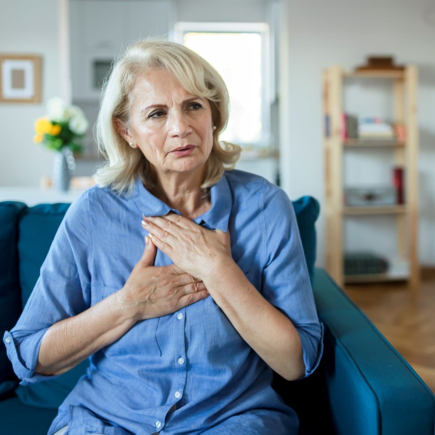 Frau hält sich im Brustbereich