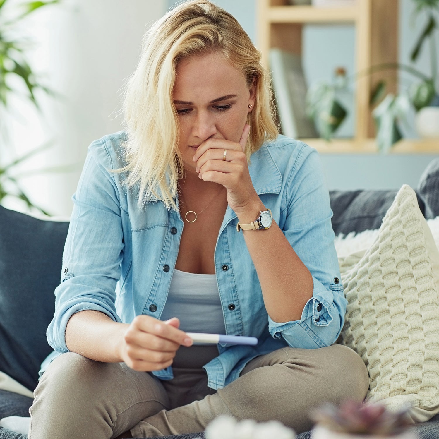 Frau hält einen Schwangerschaftstest in der Hand