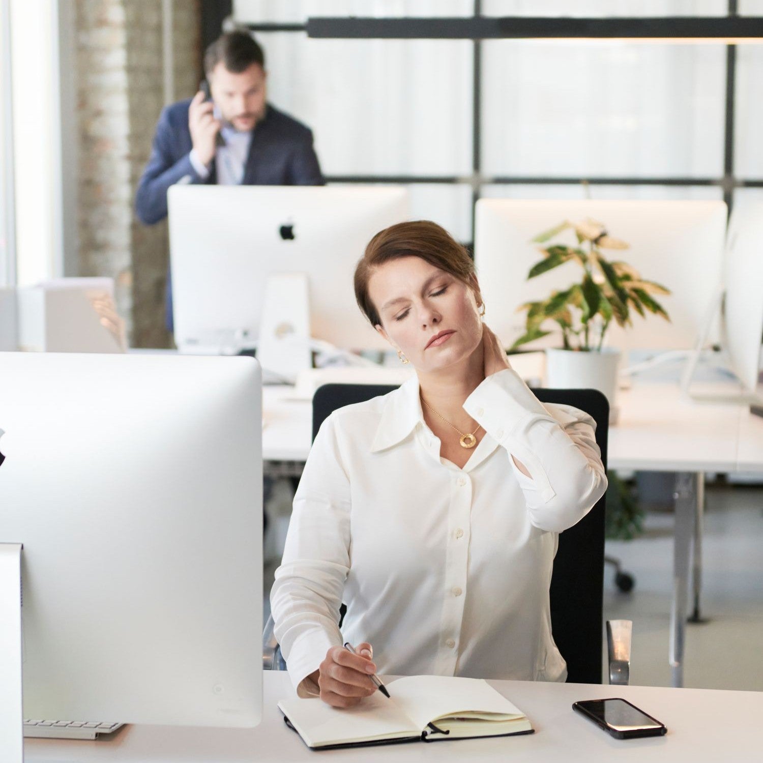 Frau dehnt ihren Nacken im Büro