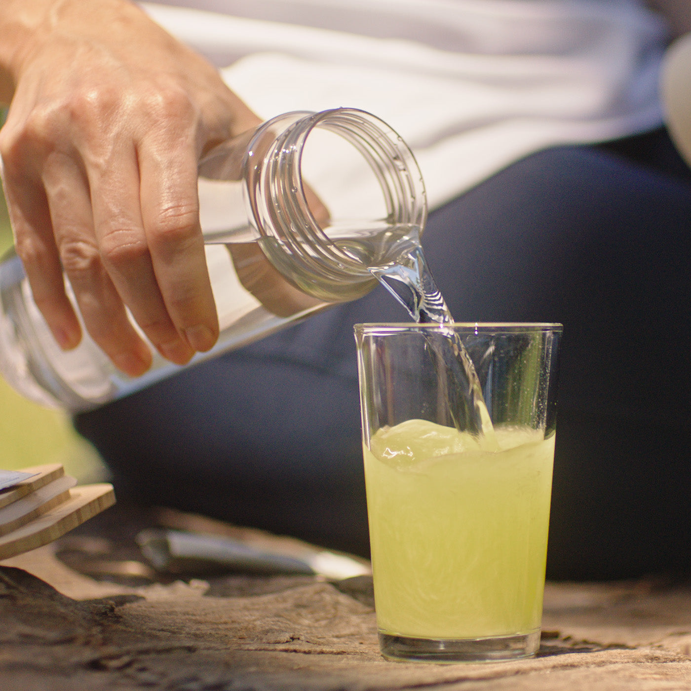 Frau schenkt Wasser in ein Glas mit einem Magnesium Trinkgranulat