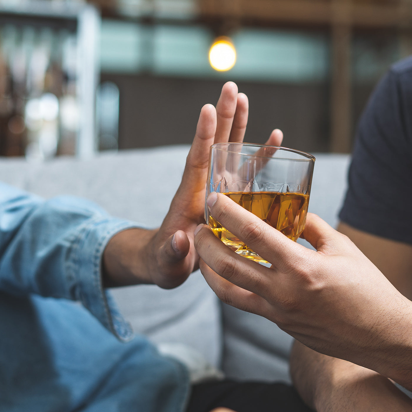 Eine Person lehnt ein Glas mit Alkohol ab