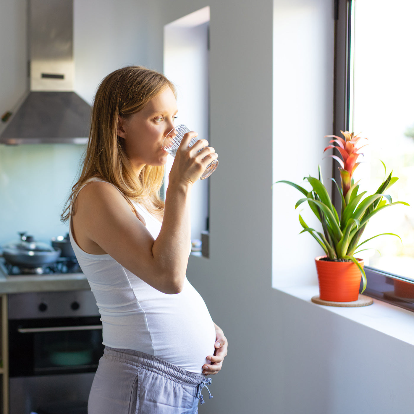 Schwangere Frau trinkt ein Glas Wasser