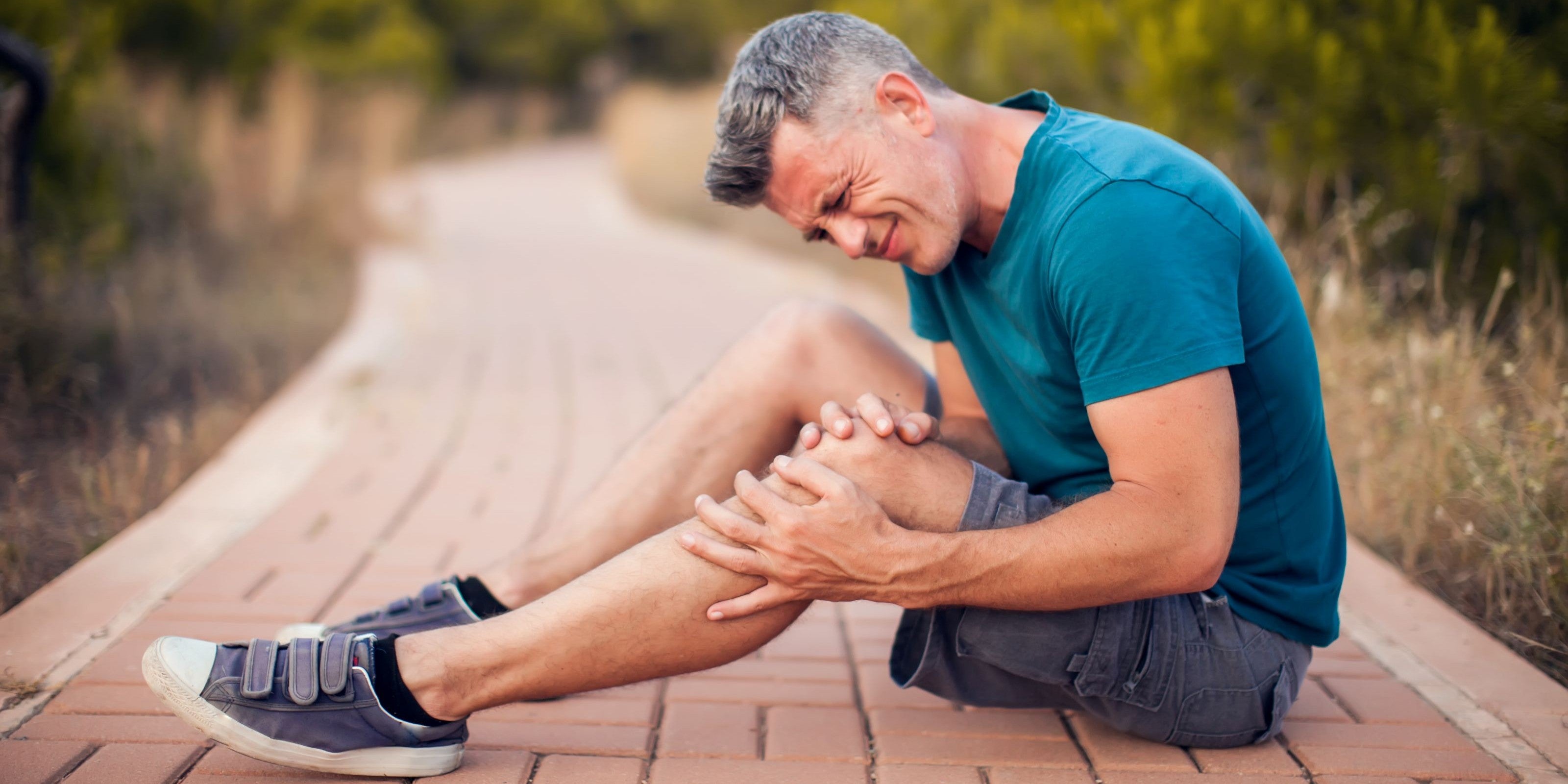 Mann war Joggen und hat einen Muskelkrampf im Bein