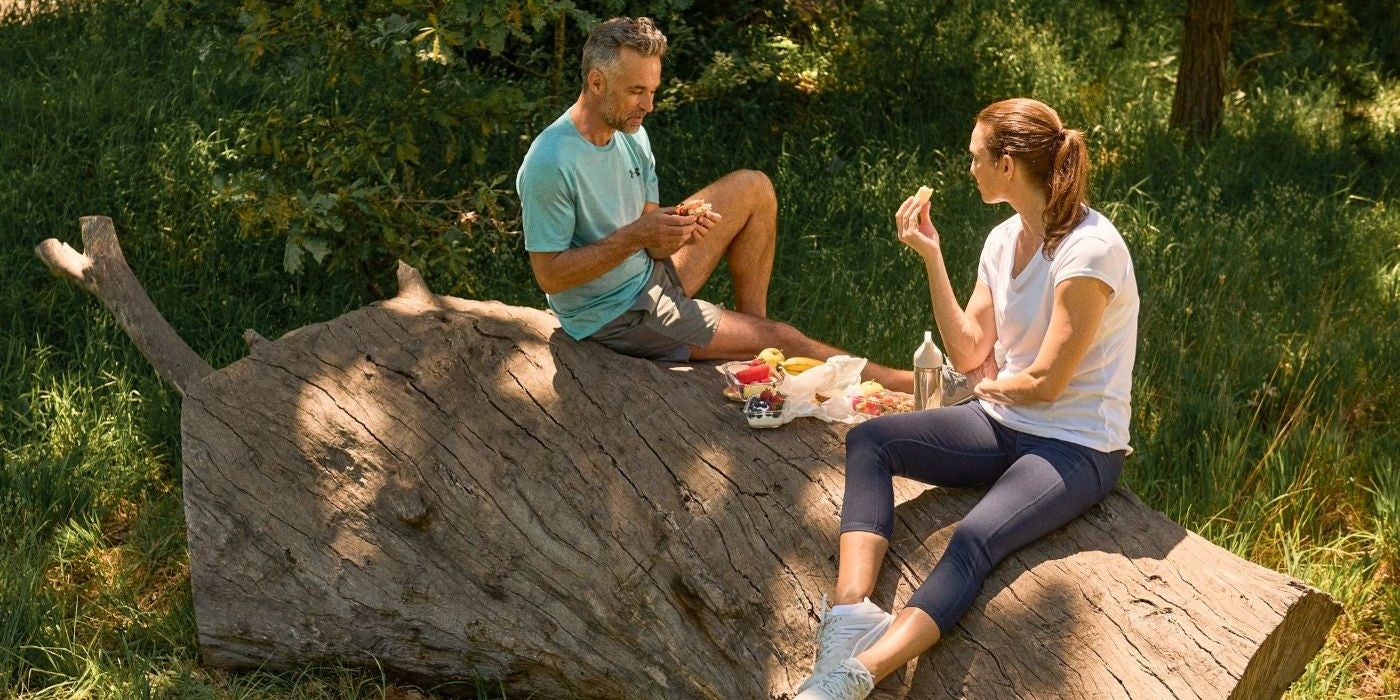 Paar macht ein Picknick auf einem Baumstamm